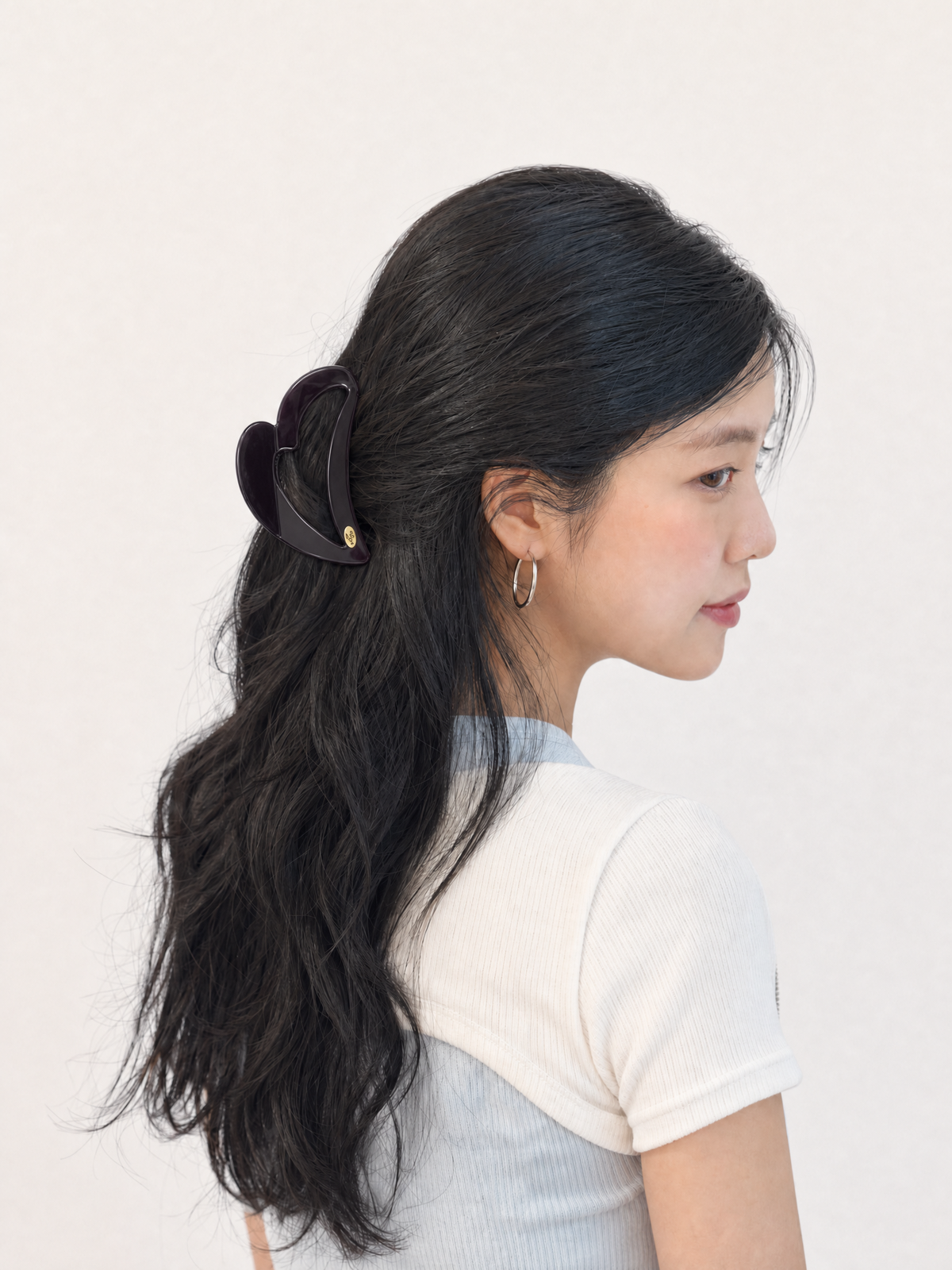 Back view of model with a French twist secured by a rich chocolate brown heart claw clip