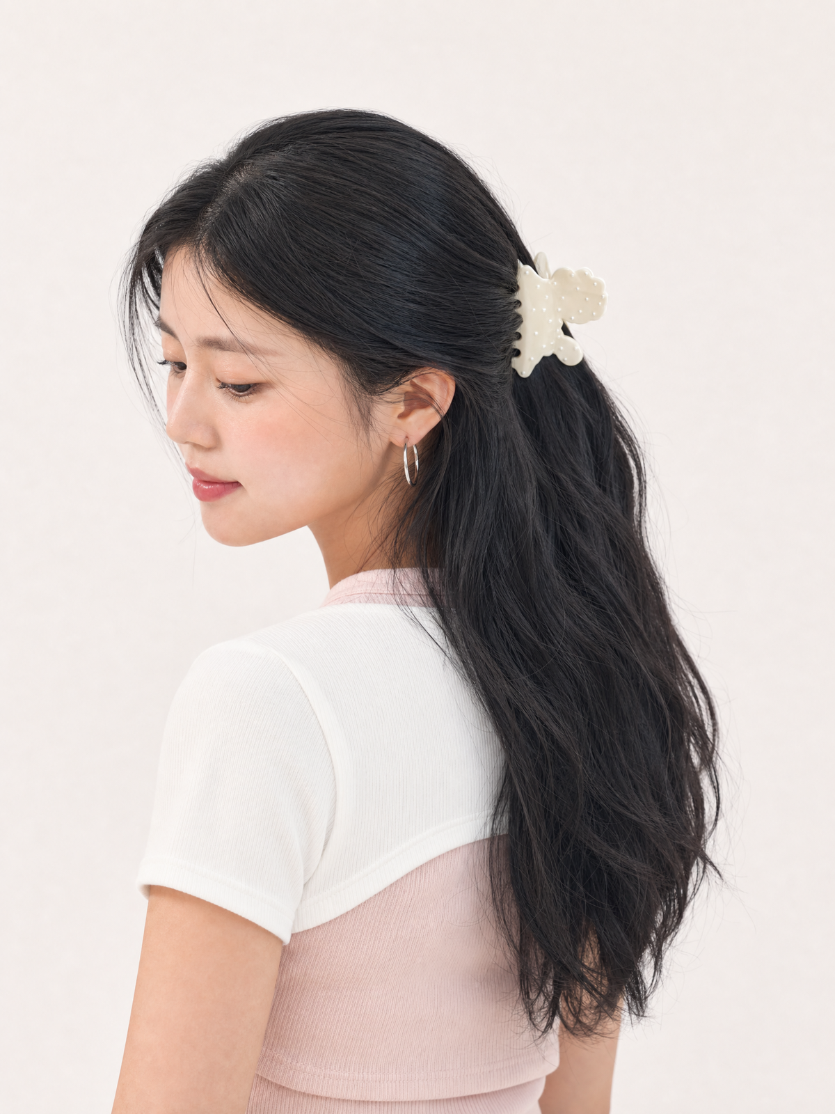 Model demonstrating a secure, non-slip grip on fine hair using the ivory polka dot puppy hair claw clip