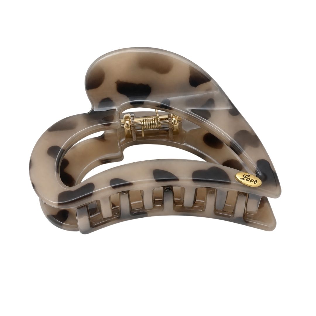 Close-up of heart-shaped acetate claw clips showing rich tortoiseshell resin patterns and strong-hold teeth