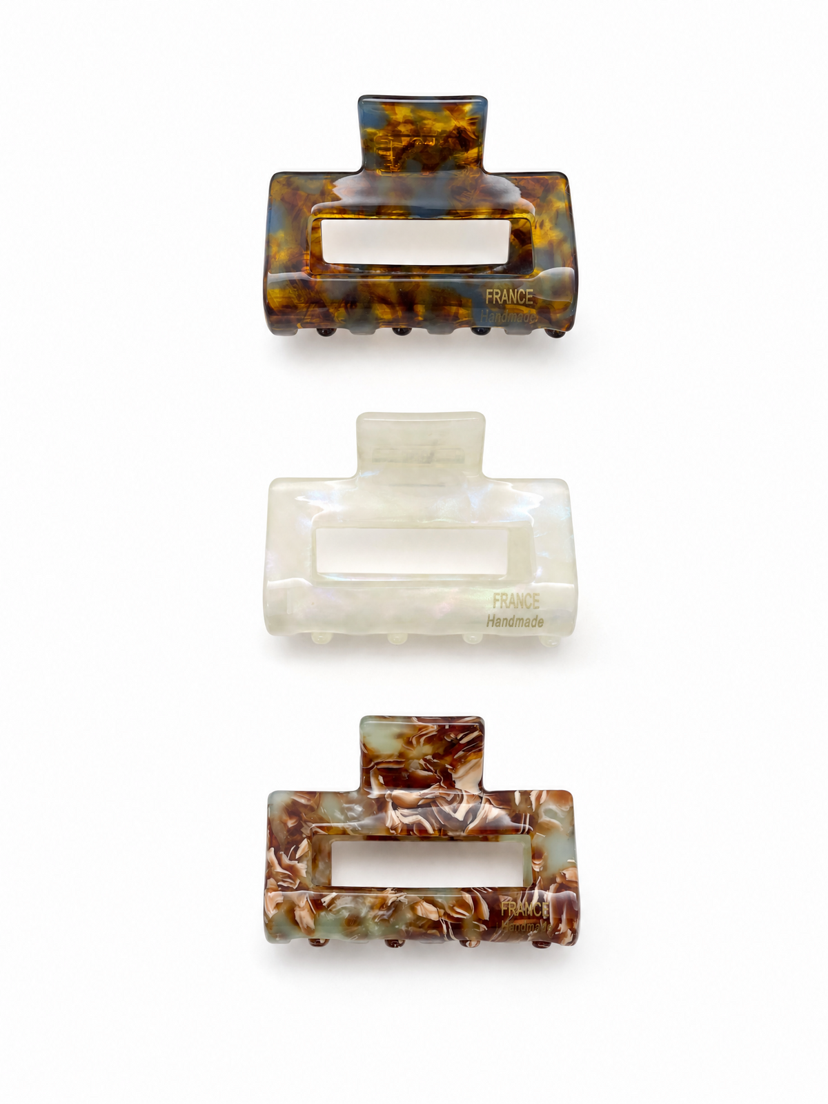 a Trio set of French medium claw clips in chestnut tortoiseshell, pearl white, and honey tortoiseshell