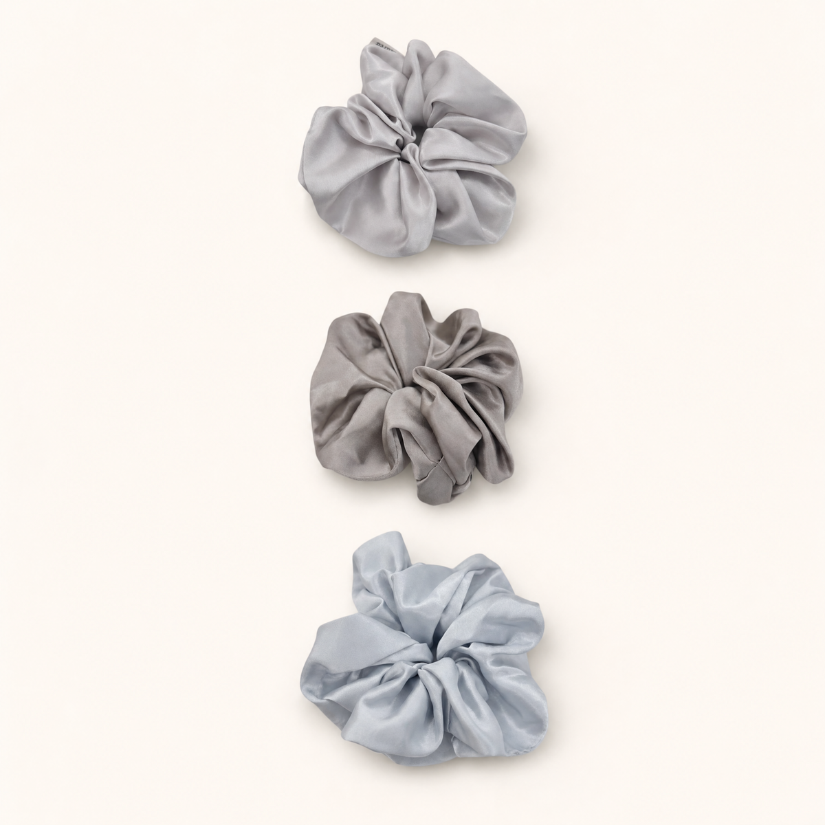 a Trio set of three French silky satin scrunchies in neutral pastel tones